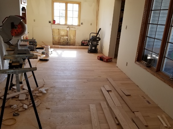 A hardwood flooring job in progress Hardwood Installation Contractors Work to Finish a Living Room in Wisconsin