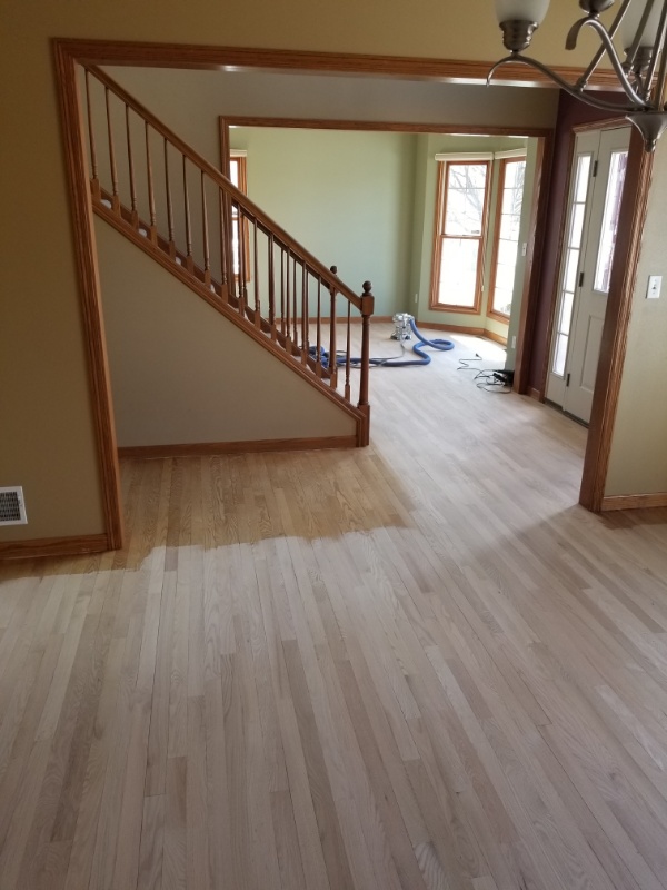 Hardwood installation contractors finish a wood entryway floor